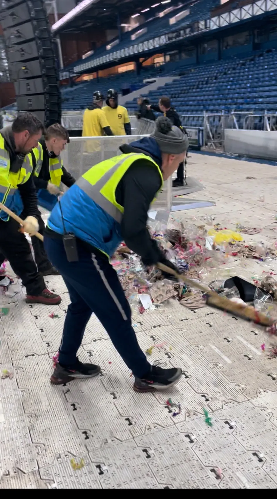 SWS cleaning team sweeping rubbish from the stadium event floor