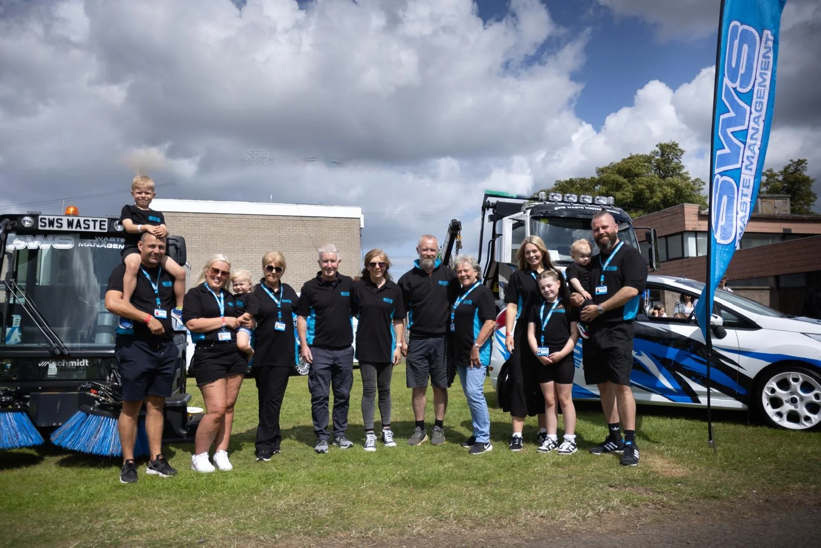 SWS family members gathered with their branded vehicles and equipment at an outdoor event